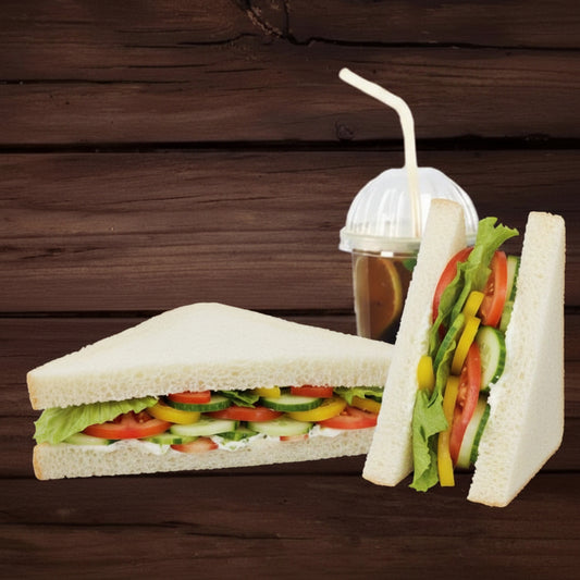 Vegetable sandwich and a drink with a straw on a wooden background